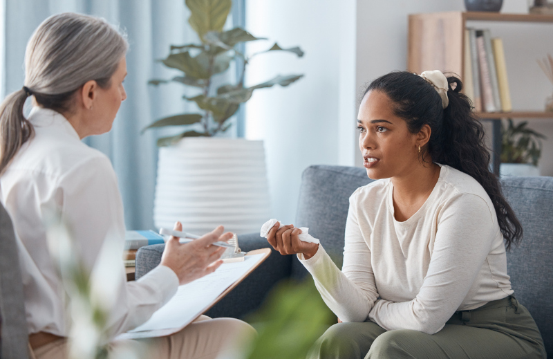 A woman learning the differences between Full-Day Treatment (PHP) and Half-Day Treatment (IOP).